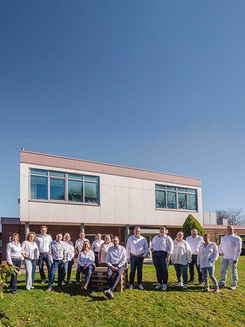Gruppenfoto vor einem Gebäude auf einer Rasenfläche