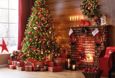 Geschmückter Weihnachtsbaum mit Geschenken vor einem Kamin